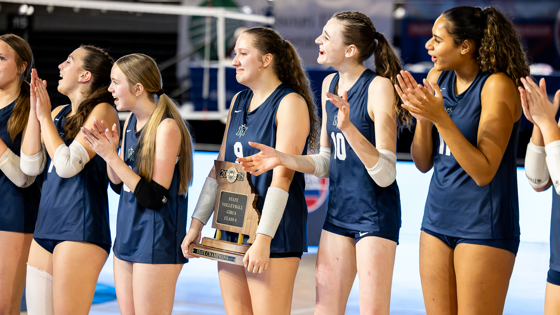Girls volleyball players celebrate with a Class 4 state championship trophy during the MSHSAA Girls Volleyball State Championships at St. Joseph Civic Arena.