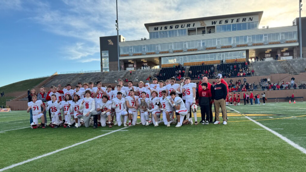 High school football state champions pose with their championship trophy on the field at Spratt Stadium at Missouri Western State University in St. Joseph.